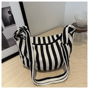 Detail of black and white striped canvas crescent bag with adjustable wide strap and zipper