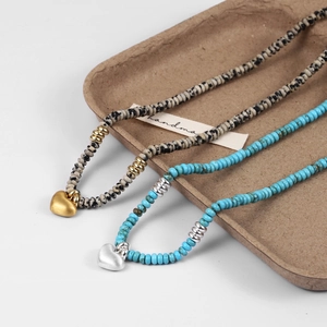 Detail of handmade beaded necklaces with turquoise, marble beads and heart pendants