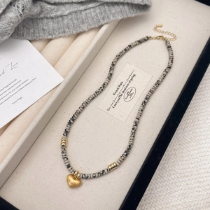 Handmade spotted natural stone beaded necklace with a matte gold heart pendant