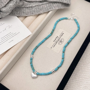 Handmade turquoise beaded necklace with matte silver heart pendant in a gift box