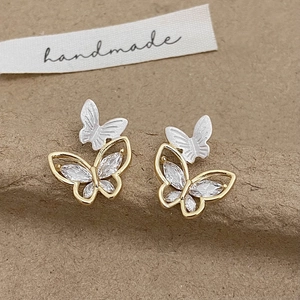 Detailed macro of two-tone butterfly earrings featuring sparkling zircon and matte finish