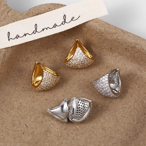 Detailed view of silver and gold triangular jewelry clasps with pavé set cubic zirconia