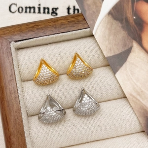 Macro detail of fan-shaped stud earrings with pavé cubic zirconia in gold and silver