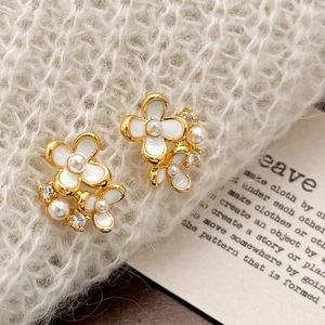 Élégantes boucles d'oreilles fleur blanche avec perles et zircons sur métal doré