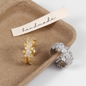 Detail of adjustable micro-pave zircon rings in gold and silver on a handmade display