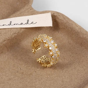 Detail of gold adjustable ring with sparkling micro-pave cubic zirconia and lace texture