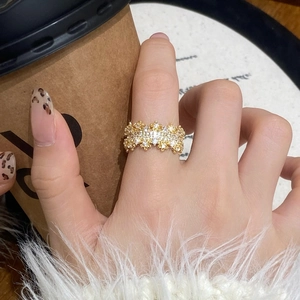Elegant gold plated wide band ring with micro-paved zircons worn in a lifestyle setting