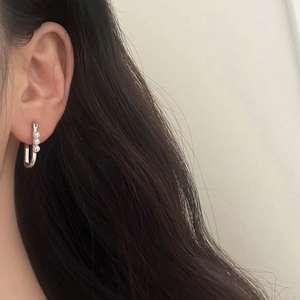 U-shaped silver earrings with three pearls on a model for a French elegant look