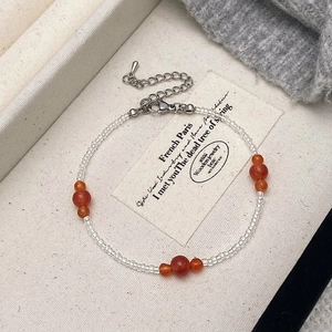 Minimalist clear beaded necklace with red natural stone accents and silver clasp finish
