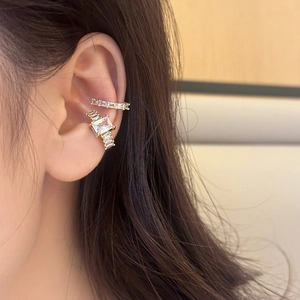 Élégants clips d'oreille dorés avec zircons étincelants portés sur le cartilage