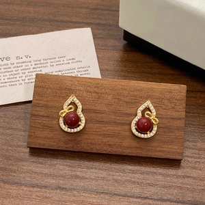 Elegant gold hulu stud earrings with red agate center and crystal bow accents
