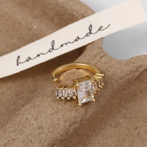 Vue détaillée d'une manchette d'oreille dorée avec un grand zircon de taille émeraude