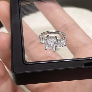 Détail du clip d'oreille argenté serti de zircons taille émeraude et trapèze