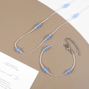 Detail view of the light blue stone beaded necklace and bracelet set with metal clasp