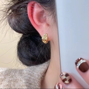 Elegant gold leaf earrings with textured hammered finish on model for daily style