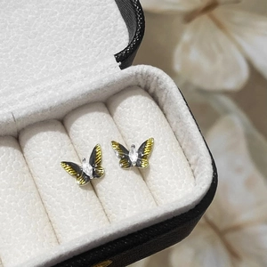 Makro-Detail von Schmelz-Schmetterlingsohrringen mit gelb-schwarzen Flügeln und Zirkonstein