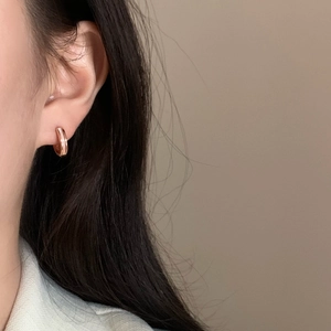 Boucles d'oreilles créoles minimalistes en or rose avec nacre portées par un mannequin
