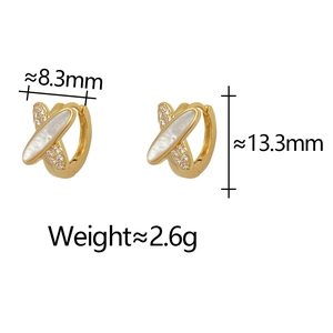 Détail de boucles d'oreilles géométriques avec zircon et nacre de perle