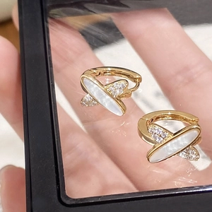 Détails des boucles d'oreilles dorées géométriques en nacre et oxydes de zirconium