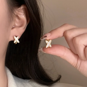 Boucles d'oreilles croisées dorées élégantes avec nacre et zircons scintillants