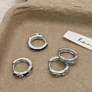 Silver butterfly hoop earrings set with black and blue enamel in a minimalist style