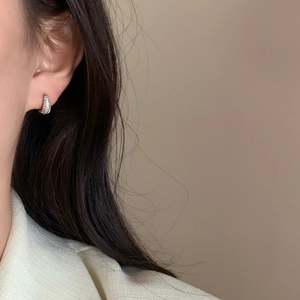 Elegant silver small hoop earrings with micro-pave crystals on a female model