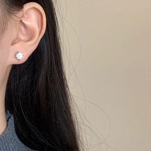 Close-up of minimalist four-prong stud earring featuring a brilliant round-cut cubic zirconia