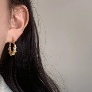 Twisted gold hoop earrings with micro-paved zircons shown on a model for daily styling