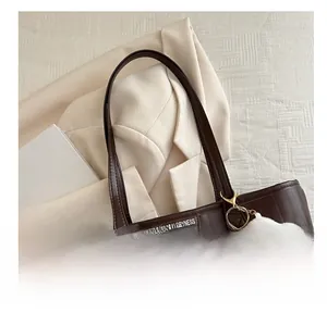 Detail of brown tote bag featuring wavy texture and a cute white cloud plush charm