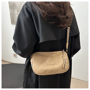 Detail of beige PU leather shoulder bag with textured surface and geometric woven strap