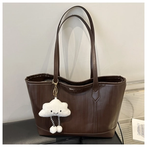 Dark brown textured tote bag with long shoulder straps and cloud charm accessory