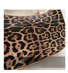 Close-up of leopard print faux leather texture with golden zipper and beige lining detail