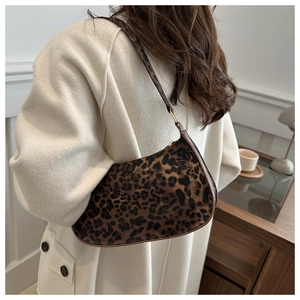 Chic leopard print baguette shoulder bag for women worn by a model in a warm interior