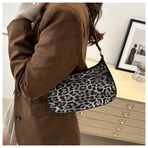 Hobo bag featuring retro leopard print worn over the shoulder with a stylish brown jacket