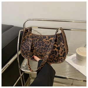 Detailed view of leopard print baguette bag with golden zipper and textured finish