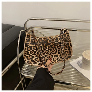 Detailed close-up of leopard print shoulder bag with zipper and crescent moon shape
