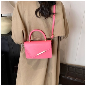 Rosafarbene Handtasche aus Leder mit goldenem Metallakzent und beigem Trenchcoat
