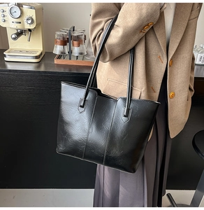 Detail of classic black PU leather tote bag featuring elegant stitching and wide shoulder straps
