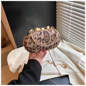 Elegante avondtas met luipaardprint, gouden vlindersluiting en fijne metalen kettingriem