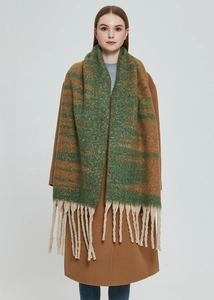 Detail of chunky knit scarf with green and brown gradient stripes and thick tassels
