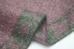 Macro detail of thick knit scarf fabric with bordeaux and dark green textured yarn weaving