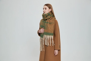 Close-up of thick chunky knit scarf with long tassels in dark green and camel stripes