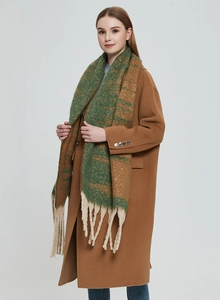 Detailed view of thick boucle knit scarf with wide green stripes and long cream tassels