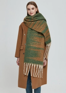 Detail of forest green and orange gradient knit scarf with thick cream fringe tassels