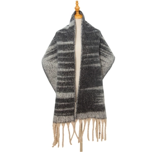 Detail of gray gradient knit scarf featuring thick fringe and chunky jacquard texture