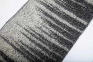 Detailed macro view of the thick boucle yarn and grey gradient stripes on the scarf