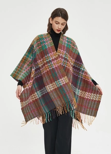 Close-up of bohemian zigzag knit shawl featuring colorful patterns and long tassel fringe