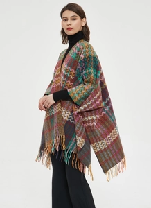 Detailed knit texture and fringe edge of the colorful chevron pattern poncho sweater