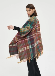 Detail of bohemian shawl with multicolor chevron pattern and long fringe trim
