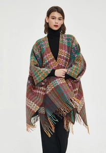 Detail of colorful knitted shawl with fringe and ethnic zig-zag jacquard pattern